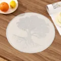 Top-down view of a round PVC placemat featuring a detailed white embossed tree design - Style I (Tree of Life) / Silver