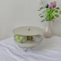 Detail of circular acrylic dessert stand in cream with lid shown in a lifestyle home setting - 21.5*21.5*16 / Gray