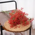 Vibrant red artificial baby's breath flowers arranged on a rustic wooden tray with a woven mat - Red