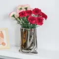 Vibrant red and pink artificial carnations in a modern silver metallic vase for home decor - Red