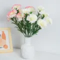 White and pink artificial carnations in a white ceramic vase for home decor. - White
