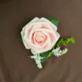 Detailopname van een lichtroze PE-roos corsage met groene bladeren en vullers - Roze
