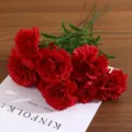Detailed view of realistic artificial red carnations with vibrant petals and green leaves - Red