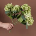 Vista dettagliata di un bouquet di ortensie verdi artificiali con cinque grandi capolini. - Verde