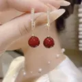 Detailed view of elegant gold hoop earrings with a red pearl drop and pavé zirconia stones - Pave Loop Red Bead Drop Earrings (E3692) / Burgundy