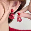 Macro detail shot showing the matte red dragon design of these festive drop earrings - Hollow Carved Dragon Pendant Earrings (E3736) / Red
