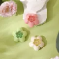 Set of three flower-shaped air freshener boxes in pastel colors on a green background - Multicolor (Mixed)