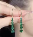 Elegant long dangle earrings with cascading green round crystals in a gold-tone finish - Long Rhinestone Tassel Earrings (E2912) / Gold