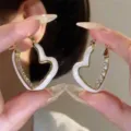 White heart-shaped hoop earrings with sparkling rhinestones and gold-tone finish - White Heart Enamel Hoops (E3342) / Gold White