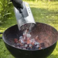 Allume-charbon en métal versant des braises de charbon dans un barbecue de jardin - 27cmx16cm