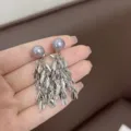 Dettaglio ravvicinato di orecchini a nappa con foglie d'argento e perle grigio viola. - Stile Foglia di Metallo Perla Grigio-Viola (E3800) / Argento