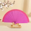 Elegante abanico plegable de madera de color magenta con soporte de madera minimalista - Rosa rojo