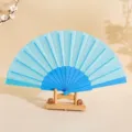 Ventaglio pieghevole glitterato azzurro da 7 pollici con telaio in plastica su supporto - 7" / Celeste
