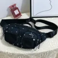 Detailed close-up of a black nylon fanny pack featuring white star patterns and mesh pockets. - Single Bag (1912) / Black
