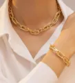 Dettaglio di una donna che indossa una collana a maglia grossa dorata e bracciale abbinato - Set Collana e Bracciale a Catena Grossa / Oro