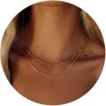 Dettaglio macro di un set di collane stratificate in oro con catena a serpente alla moda. - Catena Sottile con Perline e Catena a Serpente Piatta