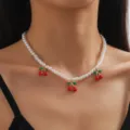 Collana con ciondolo a ciliegia ed eleganti perle finte bianche indossata da una modella - Stile Ciliegia Perla Strato Singolo / Stile 01 Oro