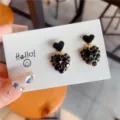 Close-up detail of heart-shaped earrings with black enamel and encrusted crystals - Heart (E0083) / Black