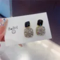 Detailed view of square gold-tone earrings with black enamel and sparkling rhinestones - Square (E0083) / Black and White