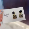 Detailed macro shot of elegant square rhinestone drop earrings with black enamel top - Square (E0083) / Gray