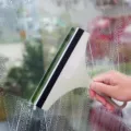 Durable cream plastic squeegee with soft black rubber blade for streak-free window cleaning - Nordic Green