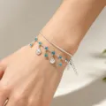 Dettaglio di un bracciale d'argento a doppio strato con strass blu e ciondoli a conchiglia - Bracciale / Argento