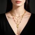 Dettaglio ravvicinato della collana a Y dorata a più strati con croce e Madonna. - Stile Croce Incisa Retrò / Oro