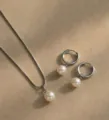 Dettaglio di un elegante set di orecchini di perle e collana con catena a serpente argento - Ciondolo Tondo (XL3919) / Rotondo Argento