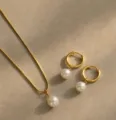 Vista dettagliata di un elegante set collana di perle d'oro e orecchini a cerchio - Ciondolo Tondo (XL3919) / Rotondo Oro
