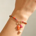 Handmade bohemian multi-colored beaded bracelet featuring spotted ceramic fish and starfish - Bracelet / Colorful