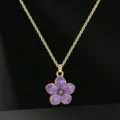 Vista dettagliata in primo piano della collana con ciondolo a fiore viola su catena oro. - Viola
