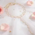 Vista detallada de un elegante collar de oro de doble capa con perlas en malla blanca - Perla Dorada
