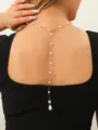 Elegant gold chain back necklace with dangling white pearl tassels shown on model. - Gold