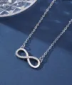 Elegant silver infinity pendant necklace with cubic zirconia stones on blue background - Silver