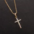 Primo piano di una collana con ciondolo a croce dorata scintillante con zirconi. - Stile Pavé Strass / Oro