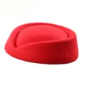 Side view of a classic red wool felt pillbox stewardess hat on white background - Red