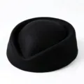 Detail of a vintage black wool pillbox hat showing smooth texture and structured shape. - Black