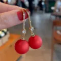 Elegante vergoldete Ohrhaken mit funkelnden Kristallen und matten roten Perlen - Kupfer-Mikropavé mit roten Perlen