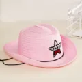 Détail d'un chapeau de cowboy en paille rose pour enfants avec un écusson étoile brodé. - Taille unique / Rose
