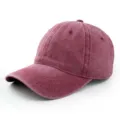 Makroansicht der Textur einer weinroten Baseballkappe aus gewaschener Baumwolle im Used-Look - Verstellbar / Burgunderrot