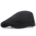 Close-up side view detail of a classic black cotton flat cap with an adjustable metal buckle - Black
