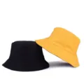 Unisex reversible solid color cotton bucket hat in black and yellow for outdoor sun protection - One Size / Reversible / Ginger/Black