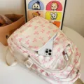 Cream backpack with pink bow print and multi-pocket design for school and travel - Pink