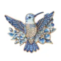 Exquisite blue enamel hummingbird brooch with sparkling rhinestones and floral detail - Blue
