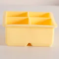 Primer plano de un molde de silicona amarillo pálido de cuatro rejillas para cubitos de hielo - Sin Tapa / 4 Rejillas / Amarillo