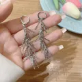 Close-up detail of elegant silver long tassel earrings with a feather-like design. - Multi-Layer Staggered Tassel Style (E3301)