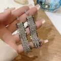 Detailed view of long silver tassel earrings featuring sparkling rhinestone fringe - Marquise Stone Top Tassel Style (E3224)