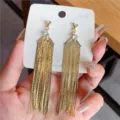 Detail view of long golden fringe tassel earrings with sparkling rhinestone accent. - Round Rhinestone Accented Fine Chain Long Tassel Style (E3199 Gold) / Gold