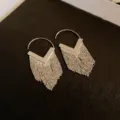 Close-up of silver-tone hoop earrings with long metallic fringe and V-shaped detail. - V-Shape Polished Piece Tassel Earring (E3128)