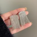 Detailed macro view of elegant long silver tassel earrings with textured metallic finish - Granular Wave Texture Long Tassel (E3024)
